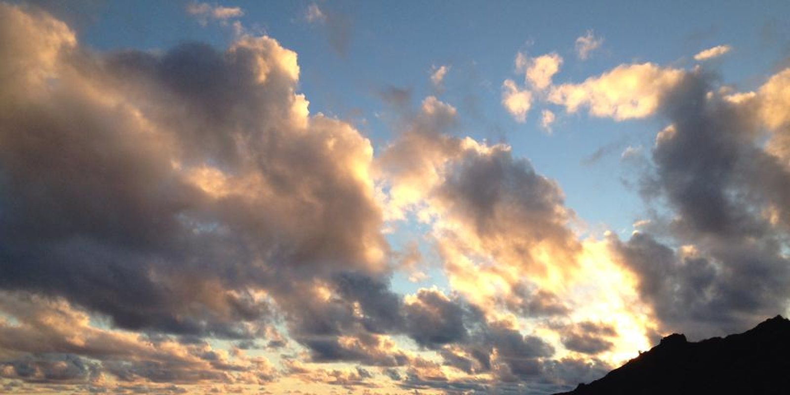 Sunset over the ocean beside a headland.